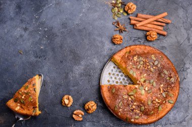 Limon aromalı balkabağı turtası, kabak tohumları, tarçın, kokulu baharatlar ve karanlık bir arka planda baharatlar. Sağlıklı ve lezzetli yemekler.