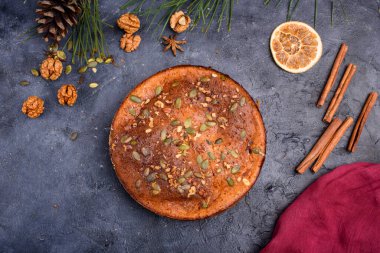 Limon aromalı balkabağı turtası, kabak tohumları, tarçın, kokulu baharatlar ve karanlık bir arka planda baharatlar. Sağlıklı ve lezzetli yemekler.