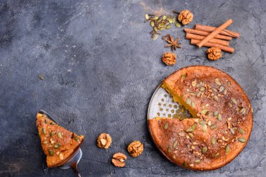 Limon aromalı balkabağı turtası, kabak tohumları, tarçın, kokulu baharatlar ve karanlık bir arka planda baharatlar. Sağlıklı ve lezzetli yemekler.