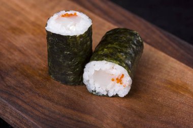 Lezzetli taze rulo, kırmızı balık, uyanma, krem peynir, marul, susam tohumu, ahşap bir değere. Somon suşi ruloları.