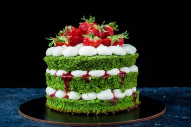 Kremalı lezzetli schnipinat keki ve koyu arkaplanda çilek. Yaratılış süreci. Pasta için doğal ürünler.