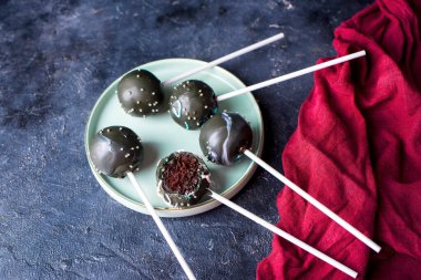 Koyu bir arka planda çubuk üzerinde lezzetli çikolatalar. Pasta tatlı atıştırmalık.