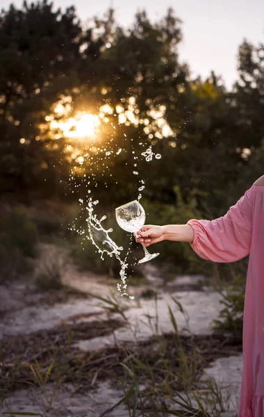 Девушка Розовом Платье Держит Красивый Стакан Воды Цветы Закате Солнца — стоковое фото