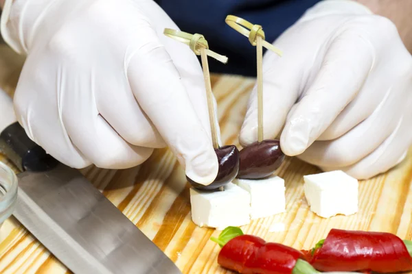 Cozinheiro prepara canapés na cozinha — Fotografia de Stock