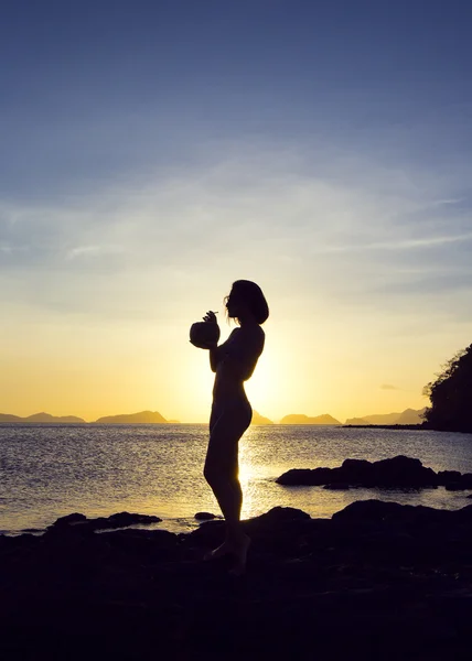 Dziewczyna z kokosem w zachód słońca — Zdjęcie stockowe