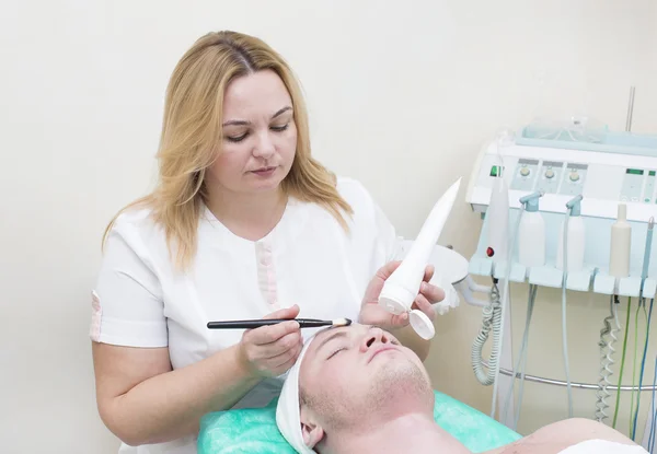 Man in the mask cosmetic procedure — Stock Photo, Image