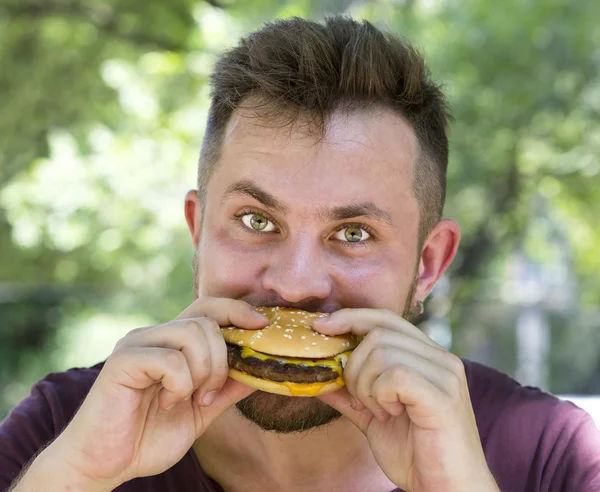 Hombre comiendo una hamburguesa —  Fotos de Stock