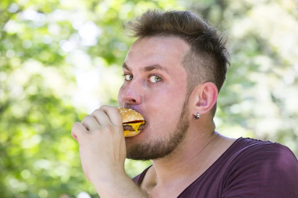 Homem comendo um hambúrguer — Fotografia de Stock