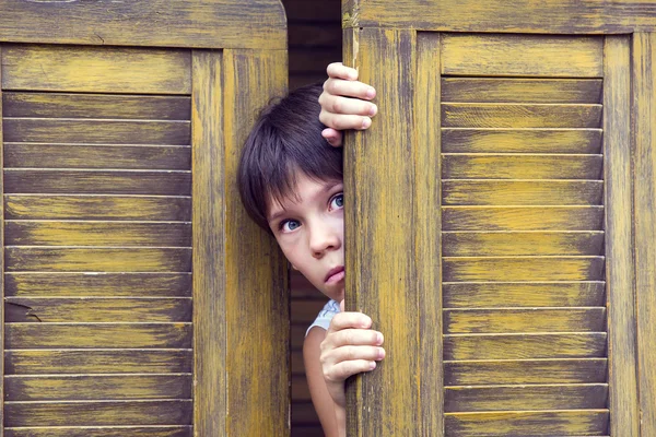 Gutt ser ut av døren – stockfoto