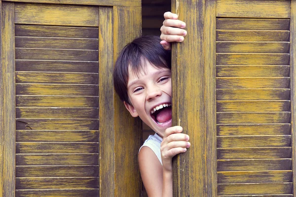 Jongen kijkt uit de deur — Stockfoto