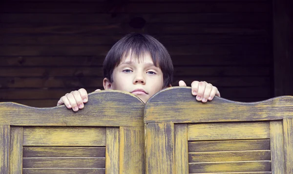 Rapaz olha para fora da porta — Fotografia de Stock