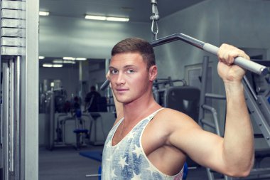 Genç adam spor salonunda antrenman yapıyor.