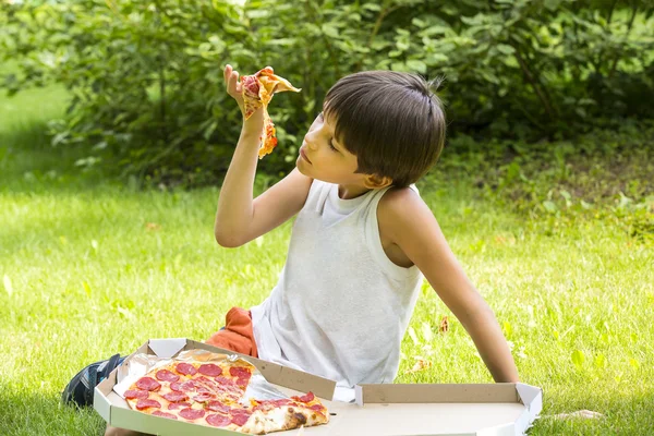 Rapaz a comer pizza — Fotografia de Stock