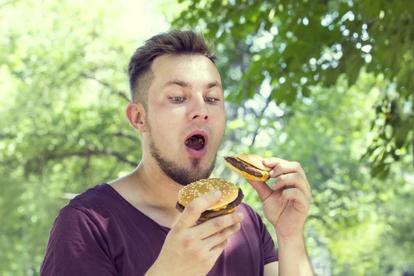 Hombre comiendo una hamburguesa —  Fotos de Stock