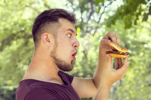 Homem comendo um hambúrguer — Fotografia de Stock