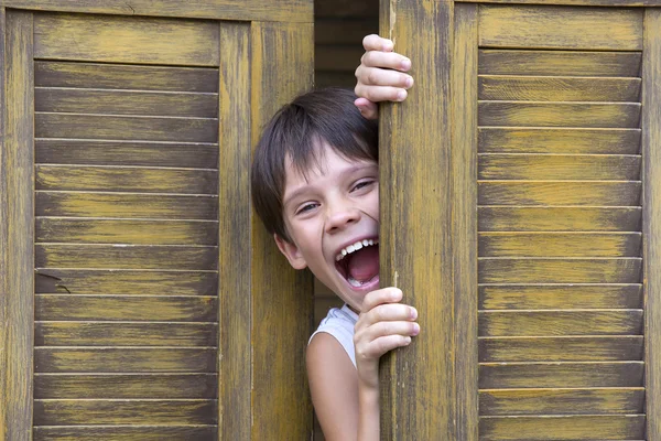 Boy looks out of the door — Stock Photo, Image