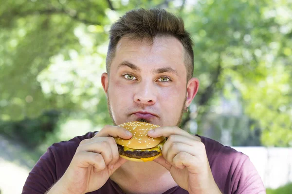 Hombre comiendo una hamburguesa —  Fotos de Stock