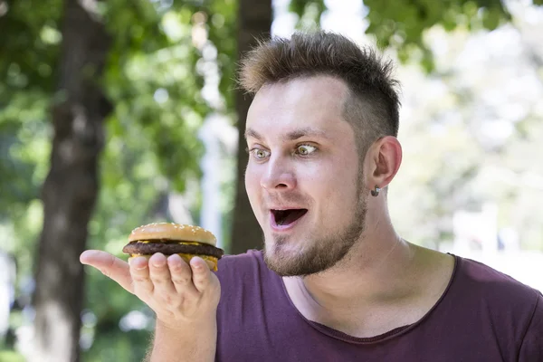 Uomo mangiare un hamburger — Foto Stock