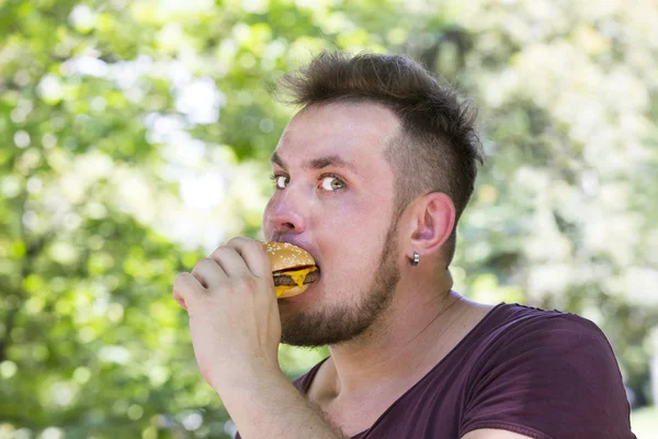 Homem comendo um hambúrguer — Fotografia de Stock