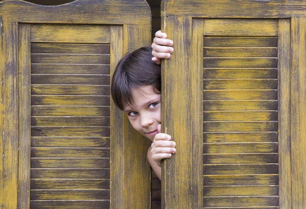 Мальчик смотрит в дверь — стоковое фото