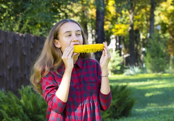 Girl eating sweet corn — Stock Photo, Image