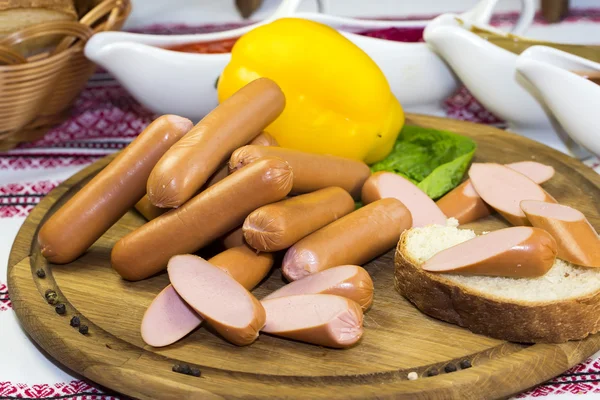 Sausages on a wooden plate — Stock Photo, Image