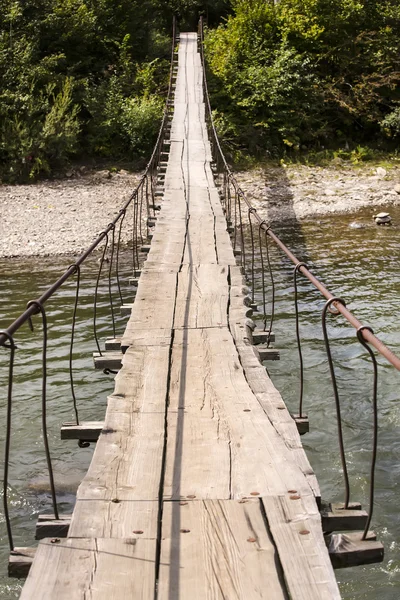 Vecchio ponte di corda attraverso il fiume di montagna — Foto Stock