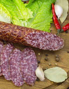 ahşap bir tabakta sebze ile sosis