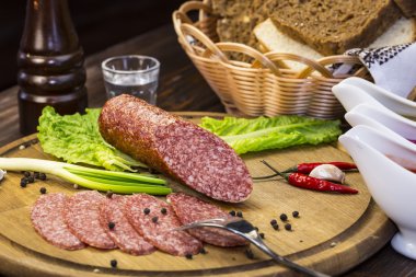 ahşap bir tabakta sebze ile sosis