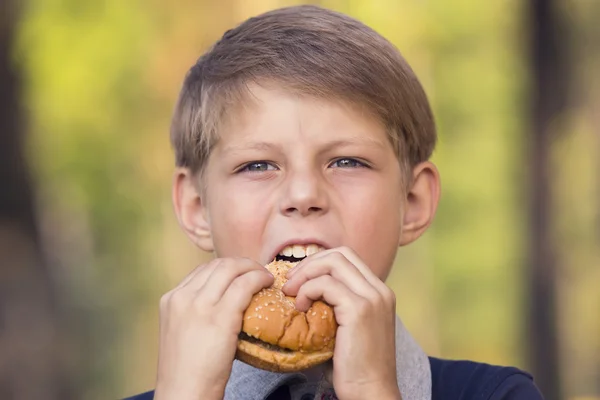 ハンバーガーを食べる少年 — ストック写真