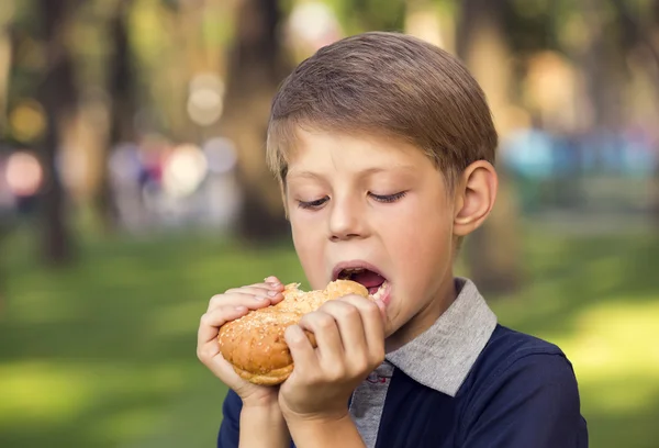 ハンバーガーを食べる少年 — ストック写真