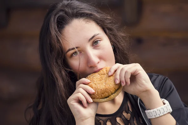Chica joven comiendo una hamburguesa — Foto de Stock