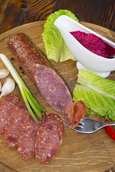 Sausages on a wooden plate — Stock Photo, Image