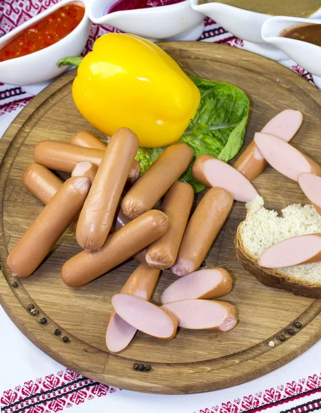 Saucisses sur une assiette en bois — Photo