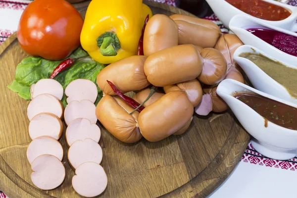 Sausages on a wooden plate — Stock Photo, Image