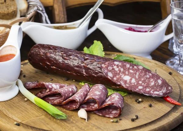 Sausages on a wooden plate — Stock Photo, Image