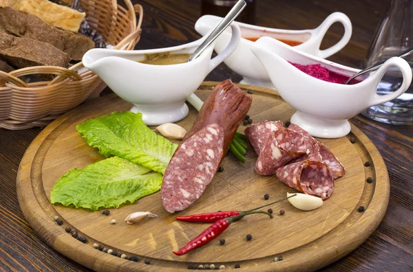 Sausages on a wooden plate — Stock Photo, Image