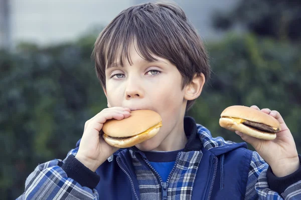 ハンバーガーを食べる少年 — ストック写真