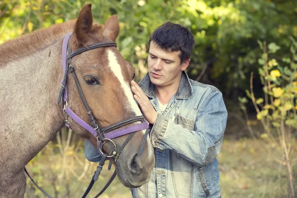 Jeune homme chevauchant cheval de race pure — Photo