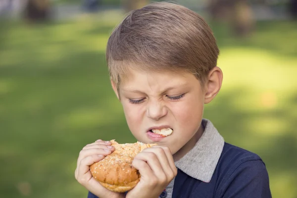 Boy eating a hamburger — Stock Photo, Image