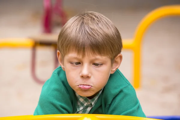 Мальчик делает лицо на детской площадке — стоковое фото