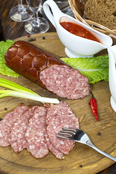 Sausage on wooden plate — Stock Photo, Image