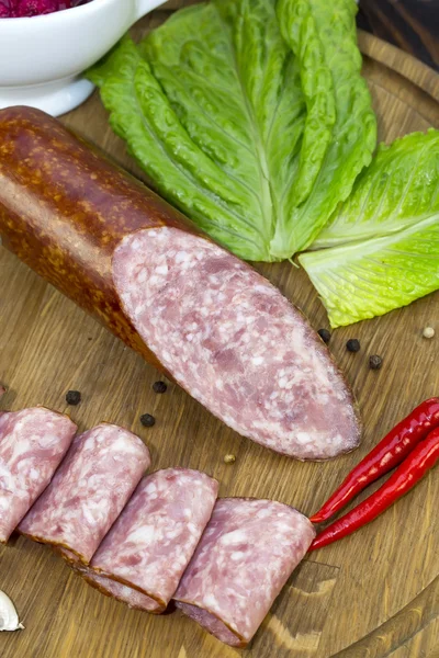 Salsiccia su piatto di legno — Foto Stock