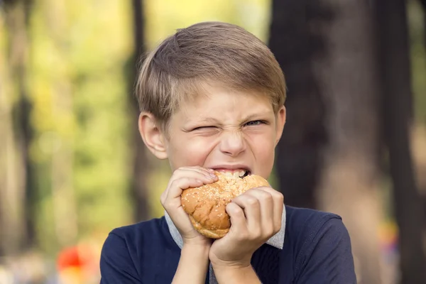 Αγόρι που τρώει ένα χάμπουργκερ — Φωτογραφία Αρχείου