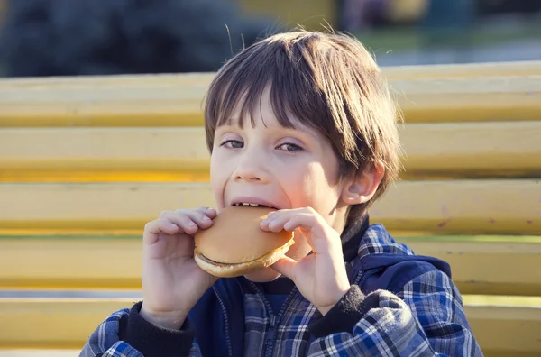 Niño comiendo una hamburguesa — Foto de Stock