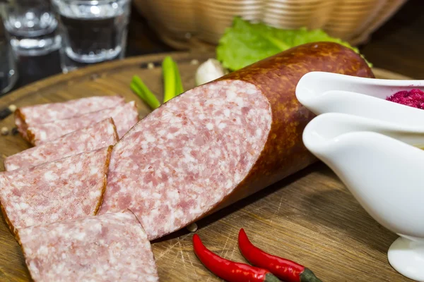 Sausage on a wooden plate — Stock Photo, Image