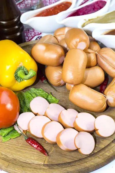 Sausages on wooden plate — Stock Photo, Image