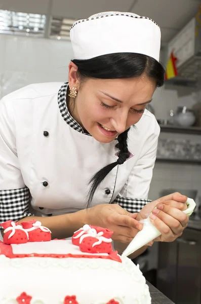 Chef de pastelaria decora um bolo — Fotografia de Stock