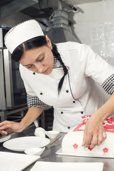 Pastry chef decorates a cake — Stock Photo, Image