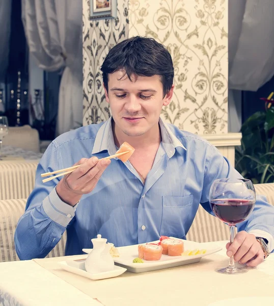 Homem comendo rolos japoneses — Fotografia de Stock